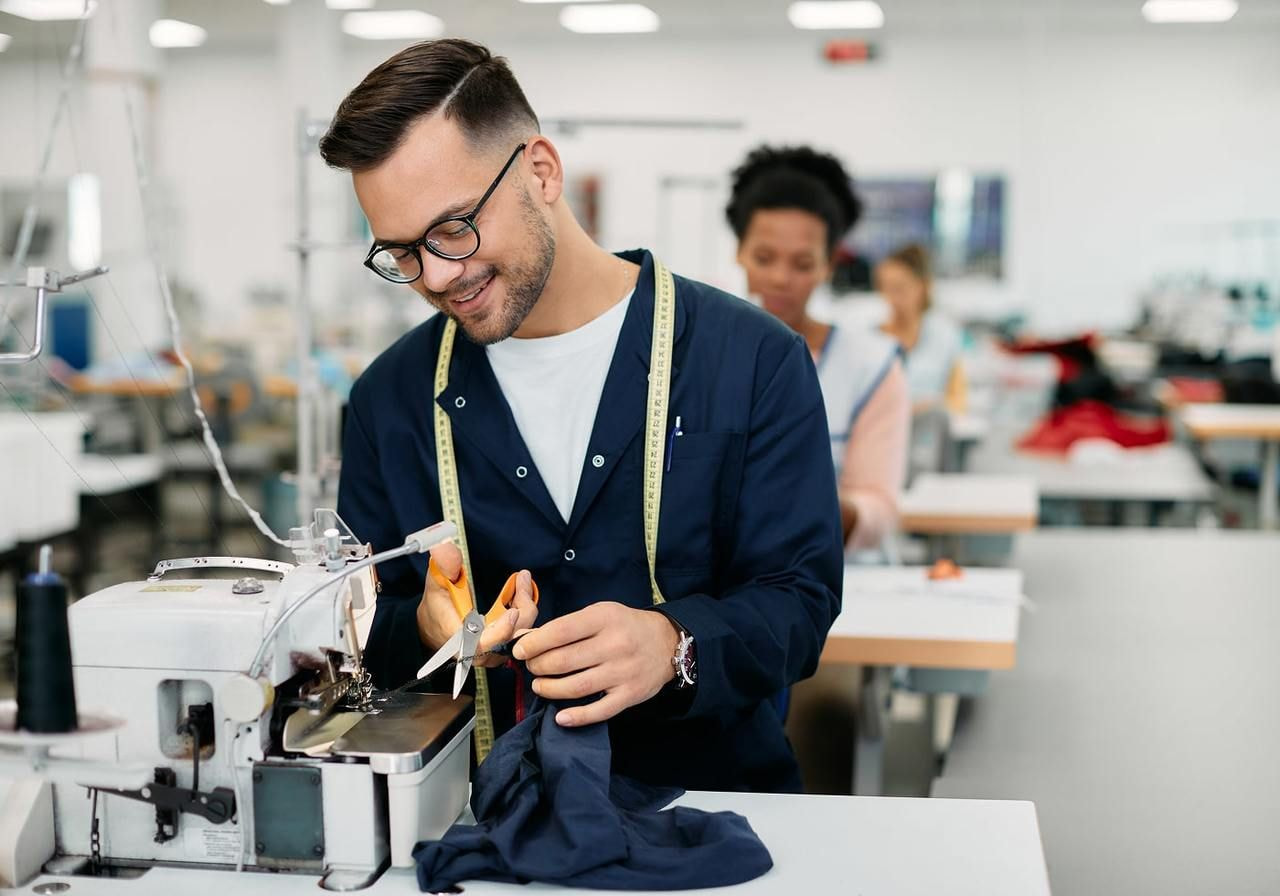 A smiling man working in a textile factory.
